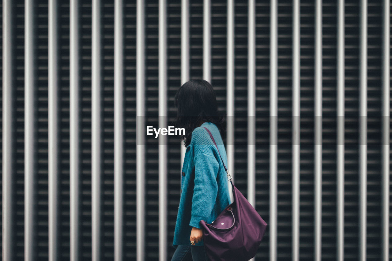 Woman walking against building