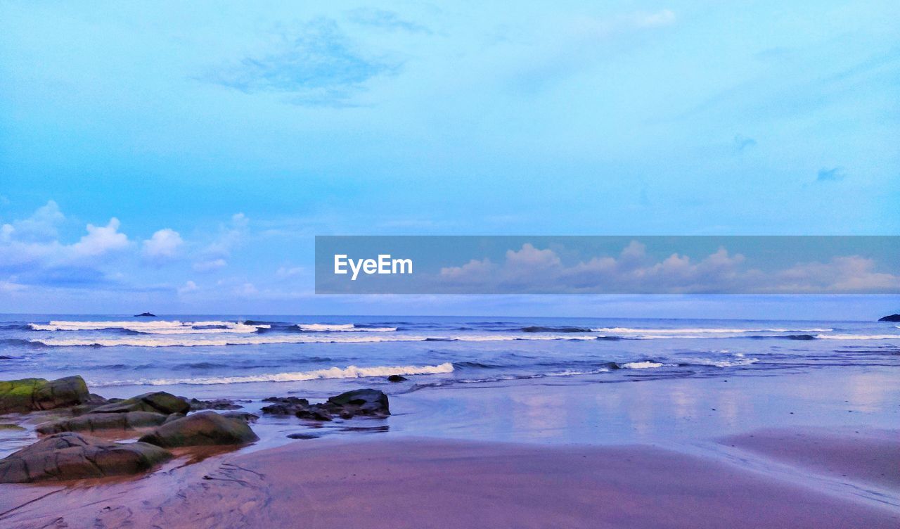 SCENIC VIEW OF BEACH AGAINST BLUE SKY