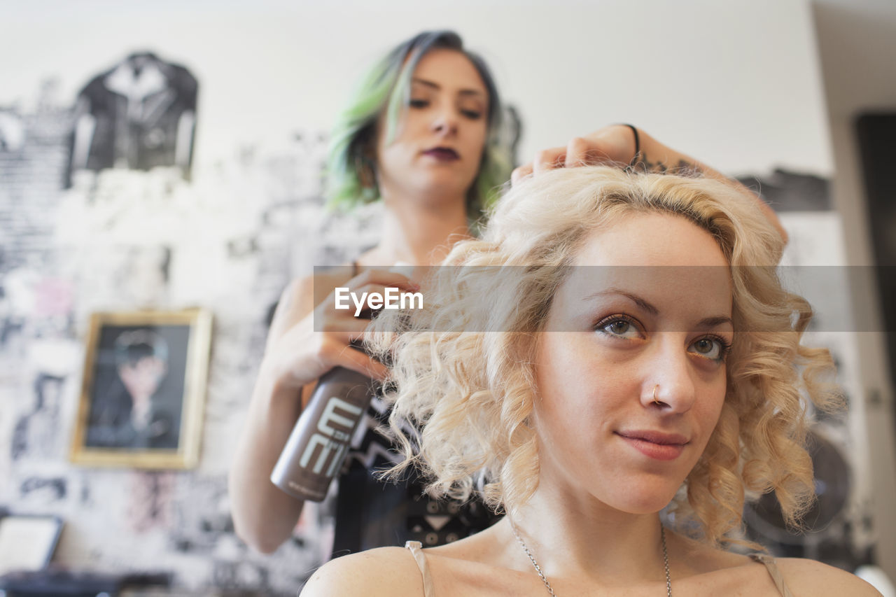 A hair dresser styling a customer's hair.