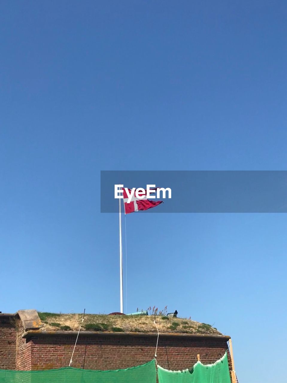 LOW ANGLE VIEW OF FLAG FLAGS AGAINST BLUE SKY