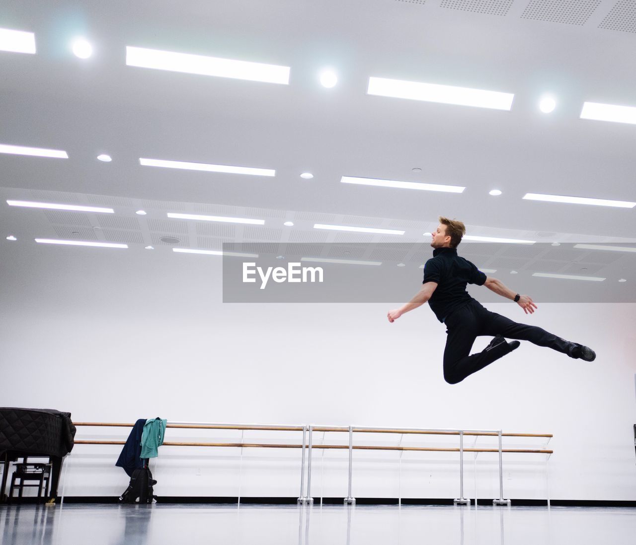 Full length of young dancer jumping in studio