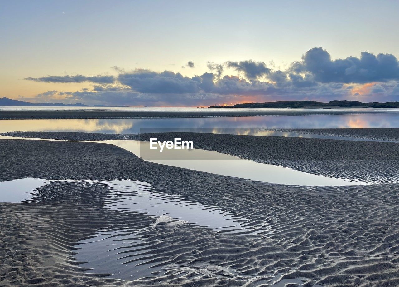 water, sky, sea, reflection, shore, scenics - nature, beauty in nature, horizon, land, nature, tranquility, cloud, ocean, environment, beach, landscape, wave, sunset, tranquil scene, body of water, coast, dawn, sand, no people, travel destinations, lagoon, travel, sunlight, outdoors, bay, idyllic, seascape, wind wave, mountain, blue, non-urban scene, sun, tourism, day, coastline, holiday, dramatic sky, horizon over water