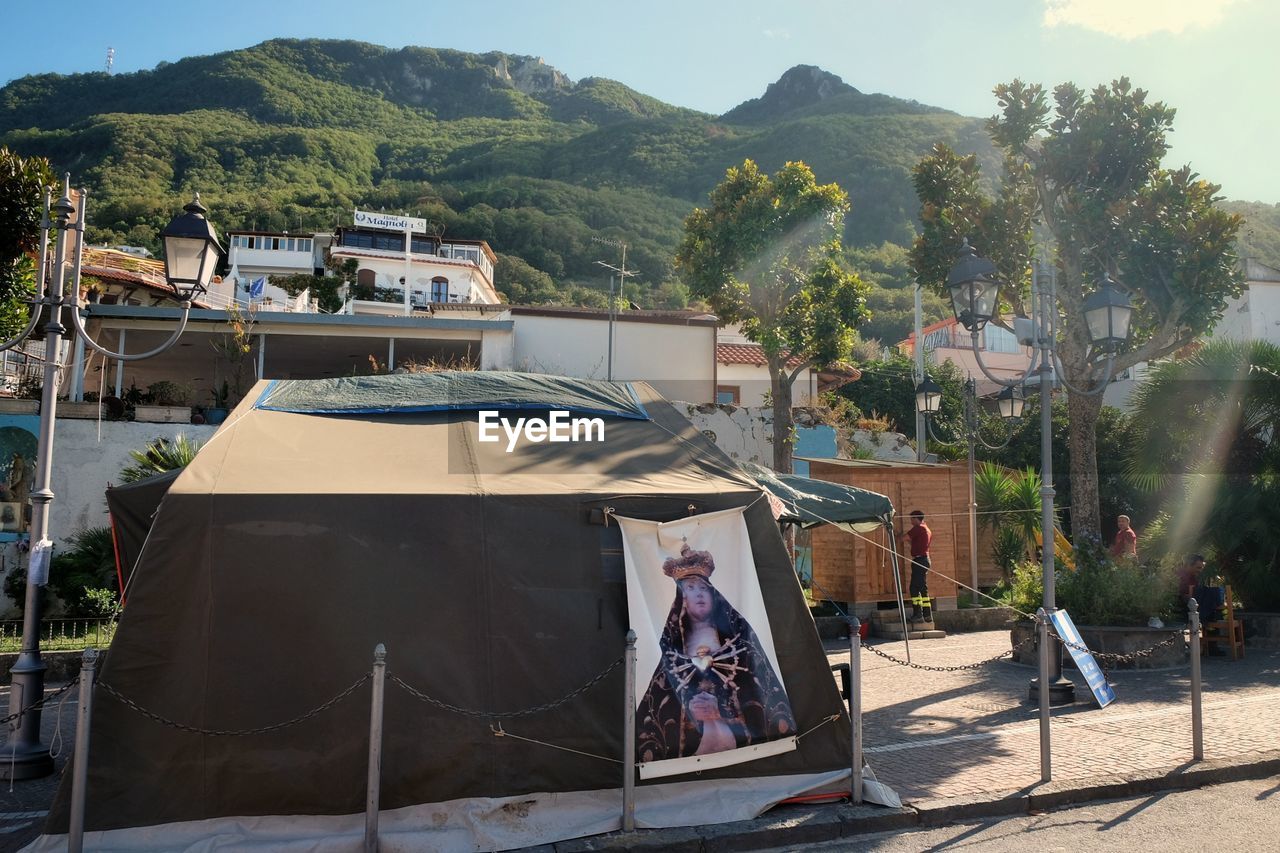 HOUSES AGAINST TREES AND MOUNTAINS