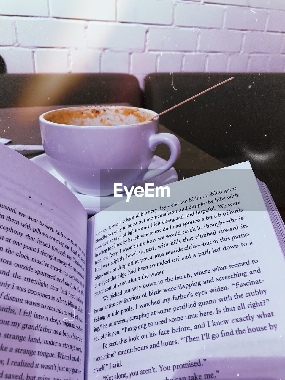 HIGH ANGLE VIEW OF COFFEE CUP WITH BOOK AND TABLE