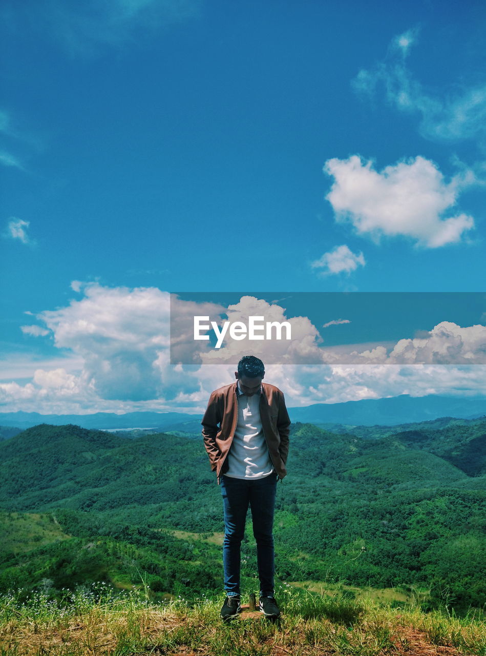 Man standing on mountain against sky