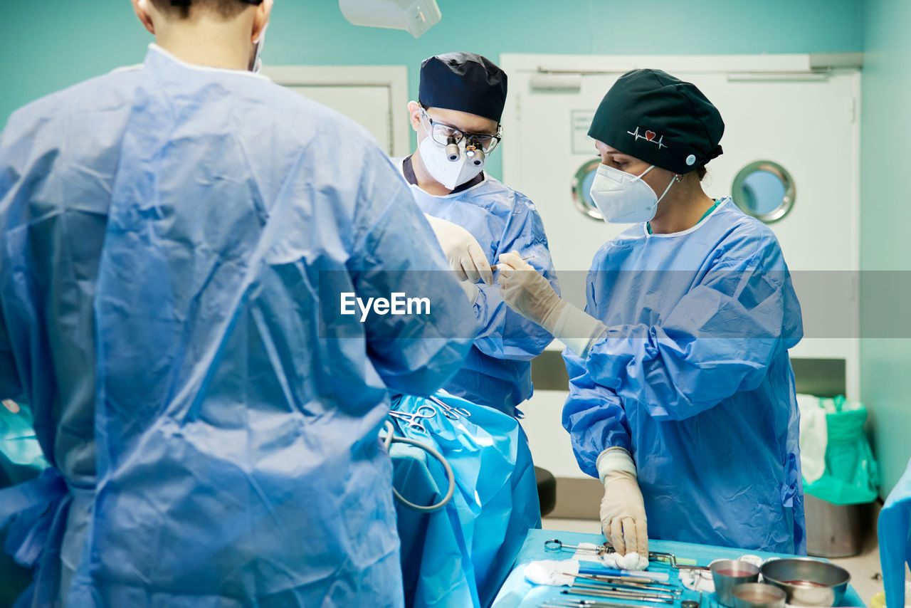 Unrecognizable surgeon with assistants during operation in clinic