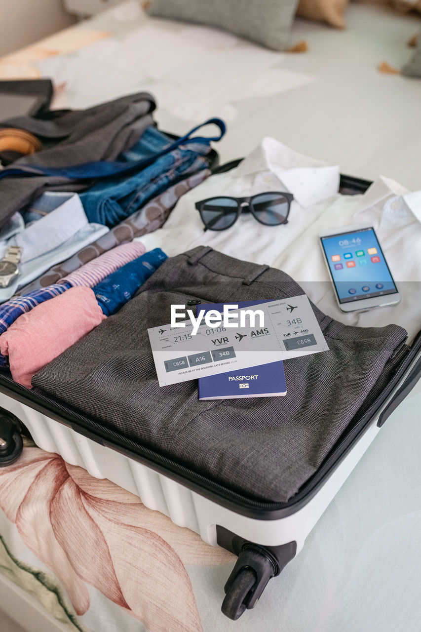 Businessman suitcase prepared for business trip with boarding pass