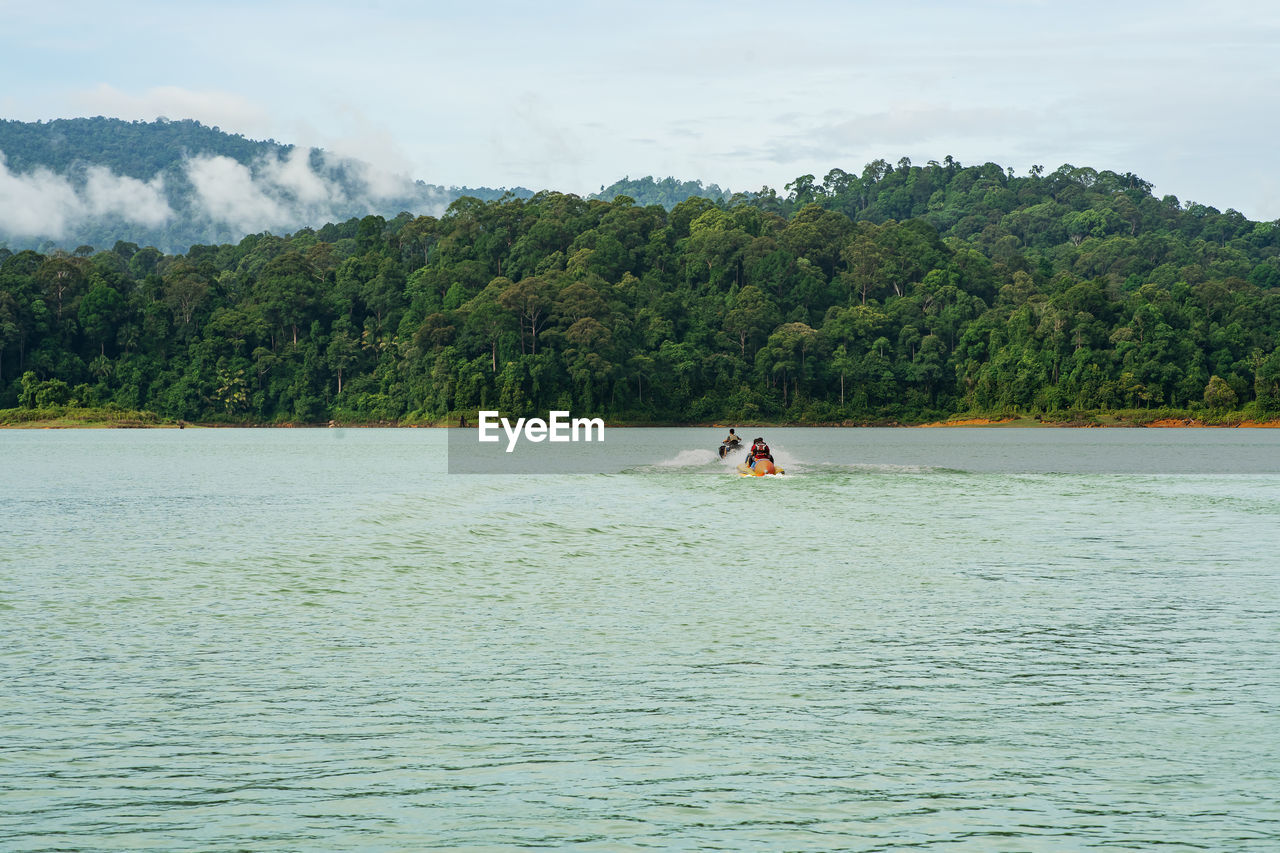People enjoying water activities on banana boat at the kenyir lake, terengganu, malaysia.
