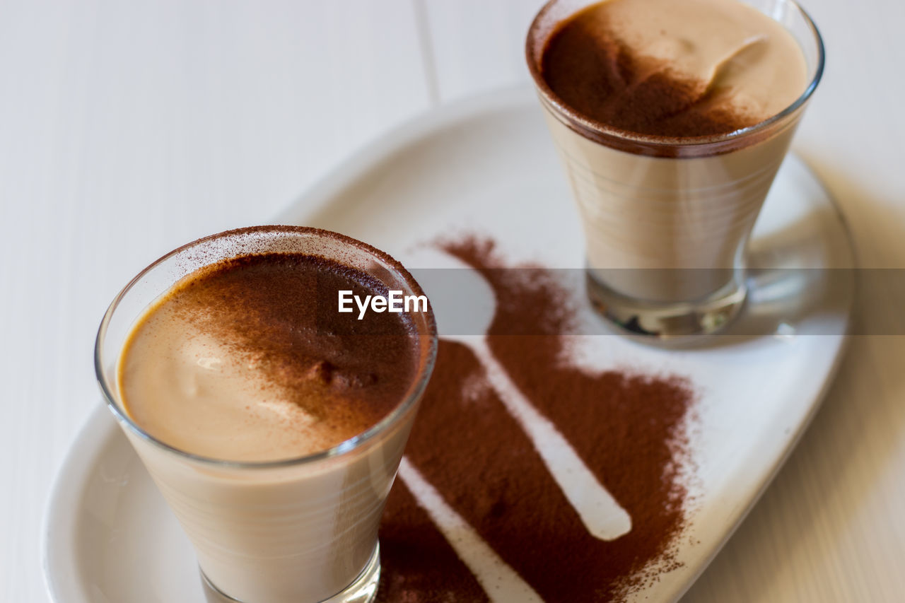 Coffee ricotta, spoon dessert in glass cup served in a white plate