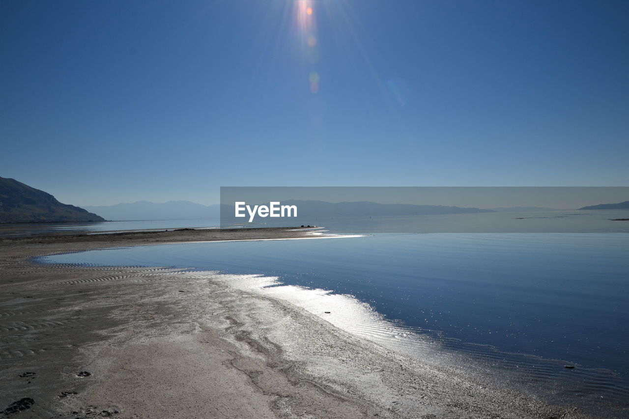 Scenic view of sea against clear sky on sunny day