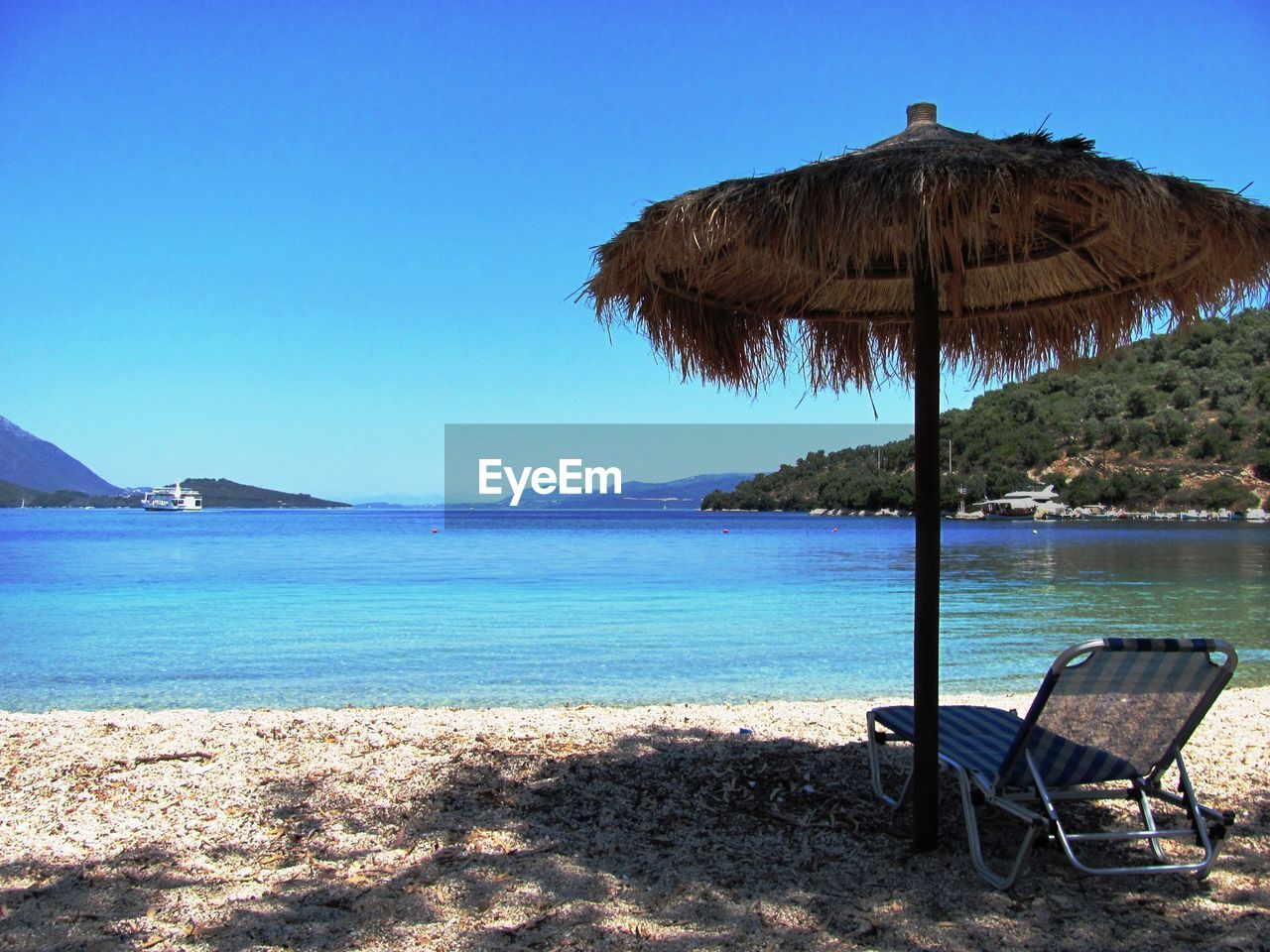 Scenic view of beach against clear blue sky