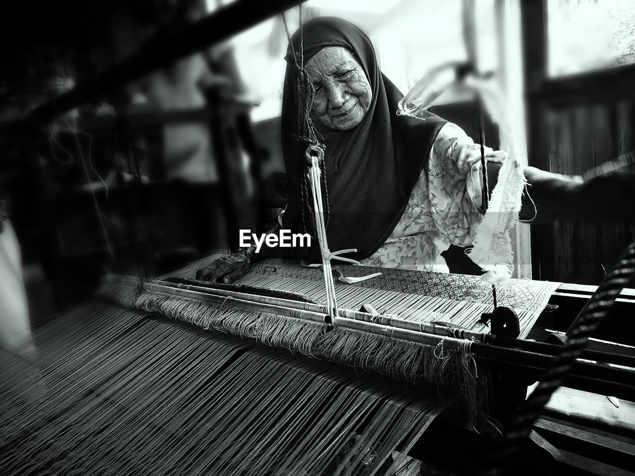 Senior woman weaving loom