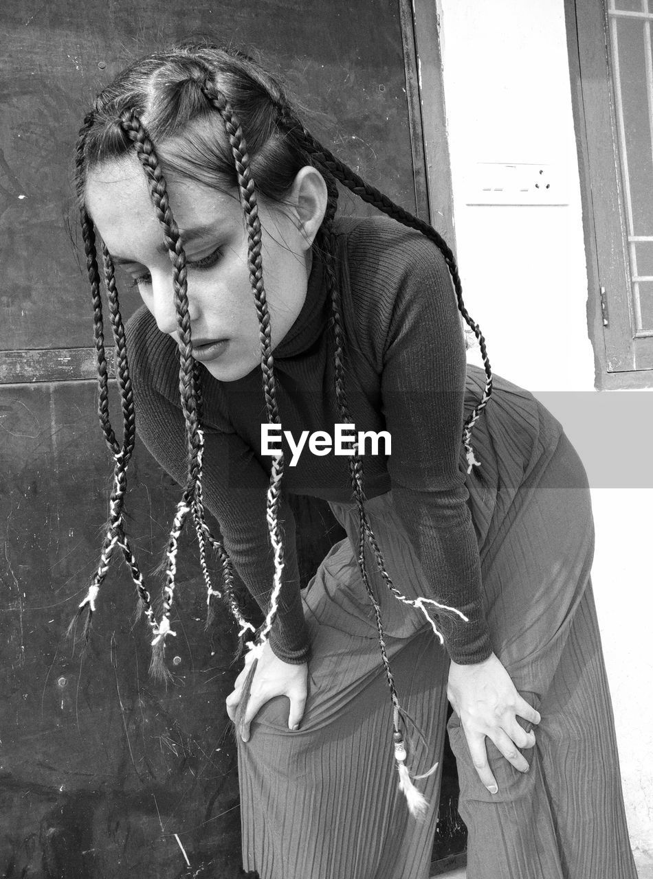 Young woman with braided hair standing outdoors