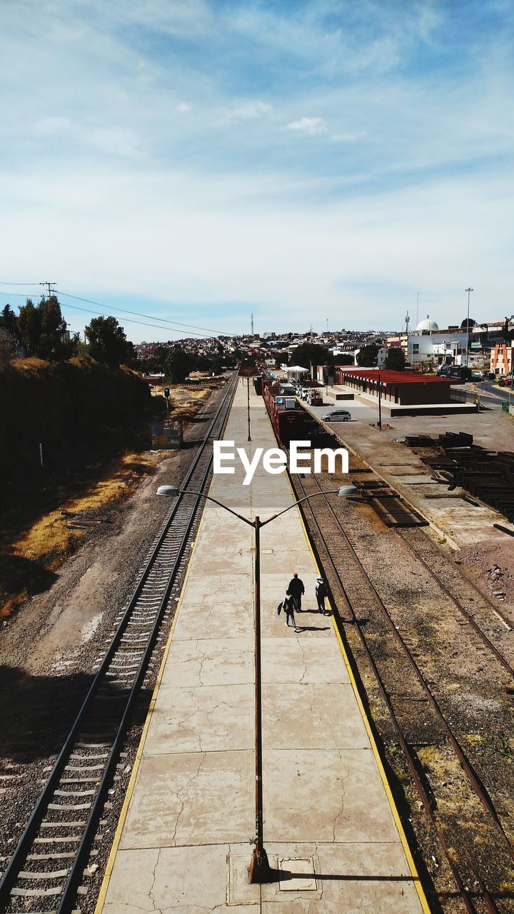 HIGH ANGLE VIEW OF RAILROAD TRACKS AMIDST SKY