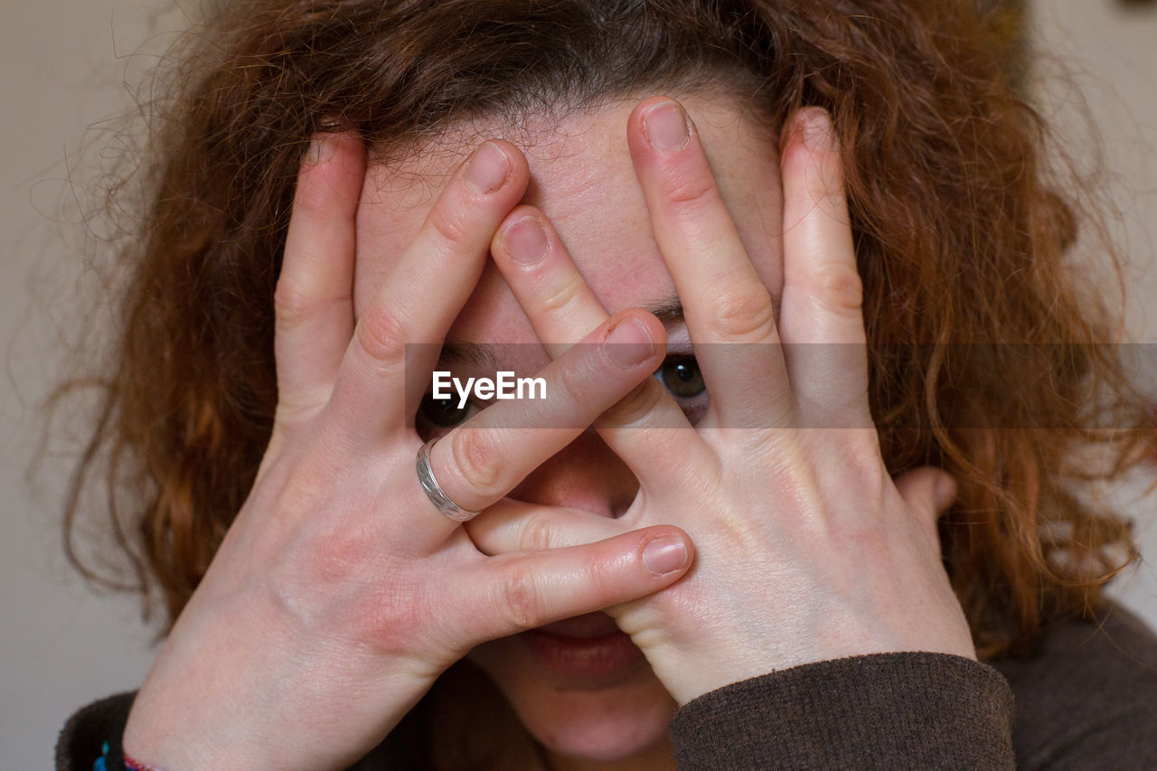 CLOSE-UP OF WOMAN COVERING FACE