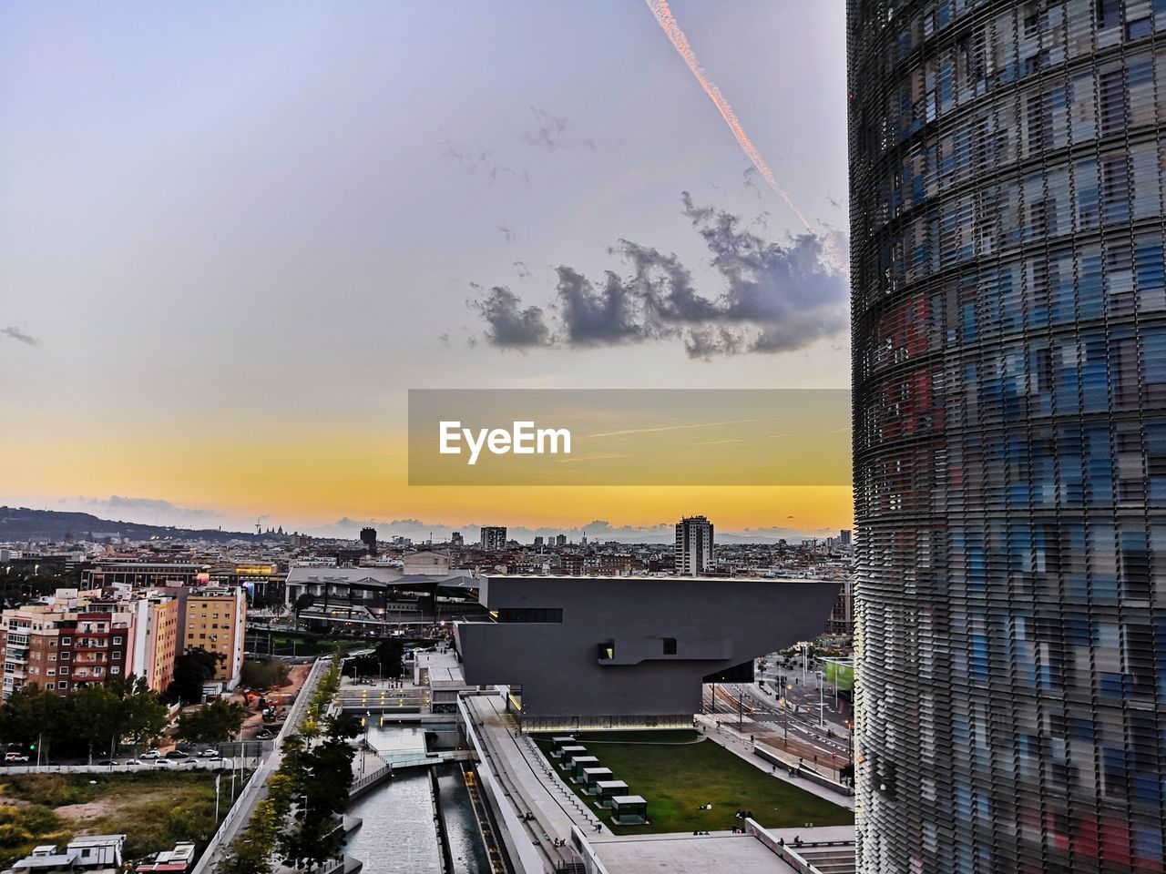 BUILDINGS IN CITY AGAINST CLOUDY SKY