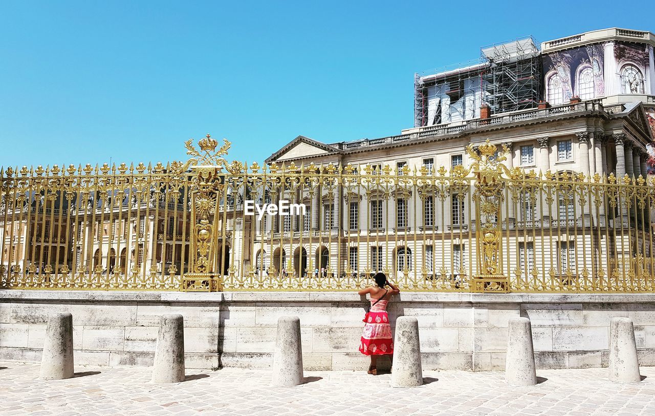 WOMAN STANDING AGAINST BUILDING