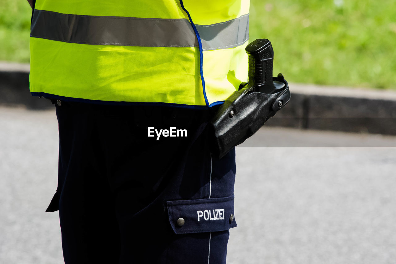 Midsection of police officer with handgun