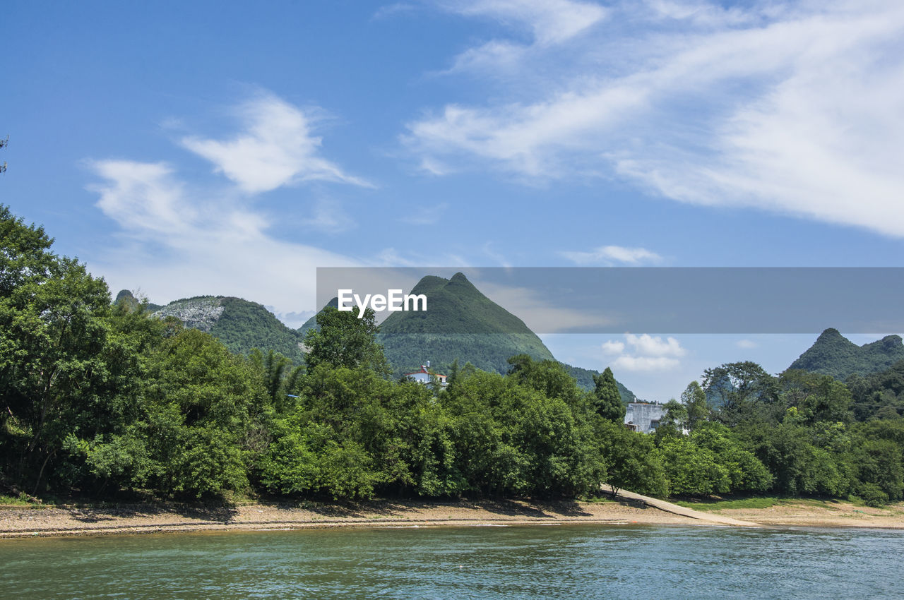 Scenic view of trees and mountains against sky