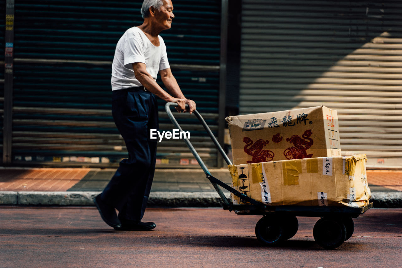 SIDE VIEW OF MAN STANDING AT BUS