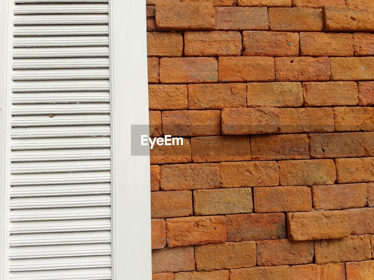 FULL FRAME SHOT OF BRICK WALL WITH BUILDING