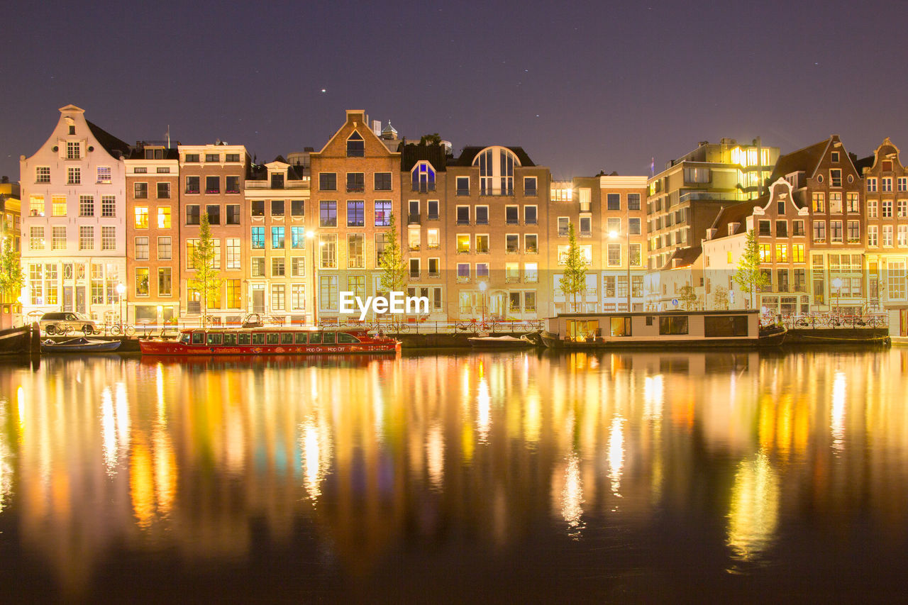 Reflection of illuminated buildings in river at night