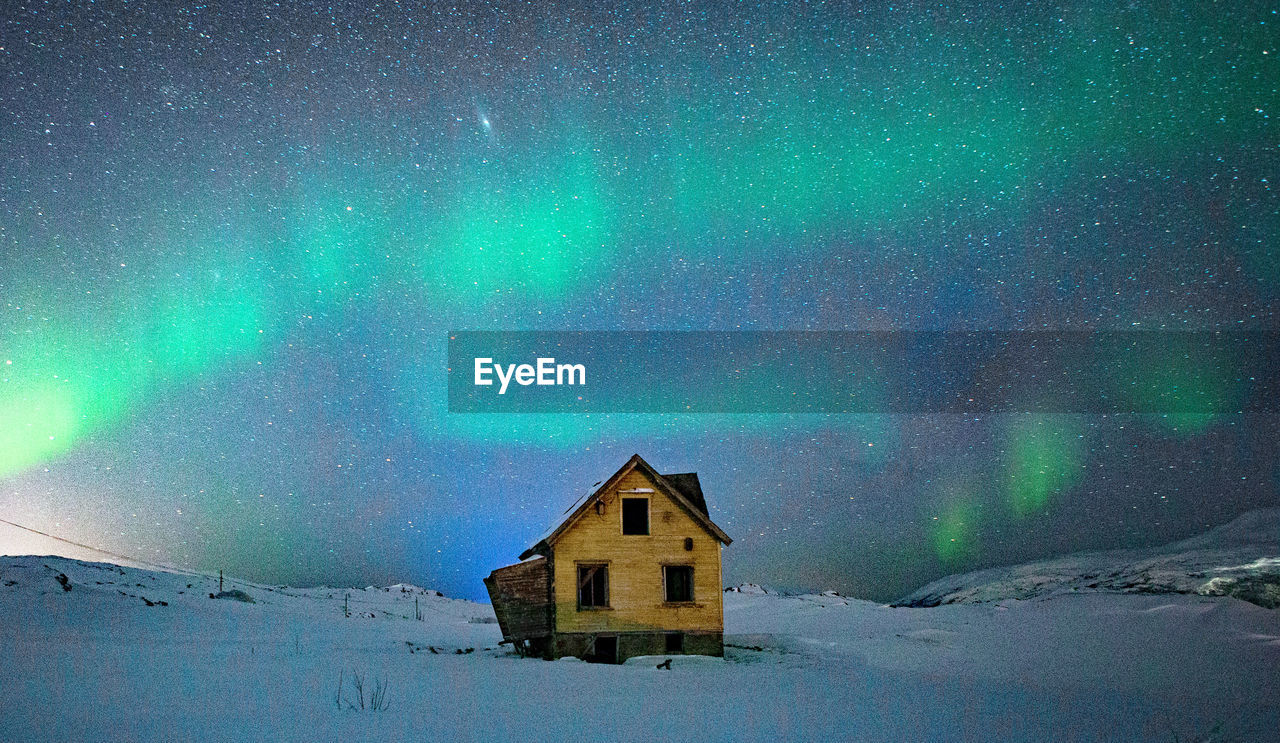 Northern lights over a derelict barn in tromso, norway