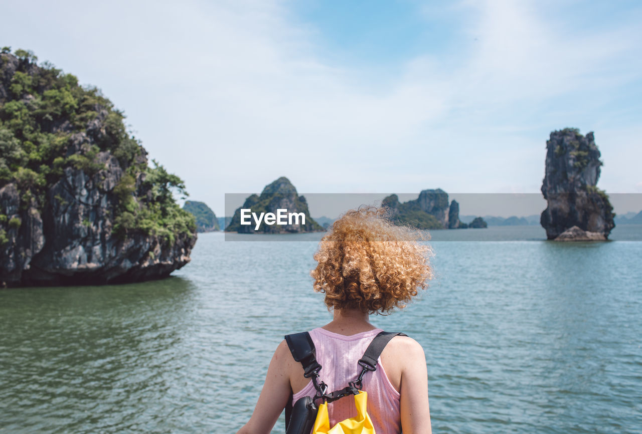 Rear view of woman looking at sea against sky