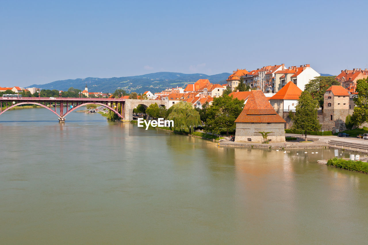 Bridge over river against buildings in city