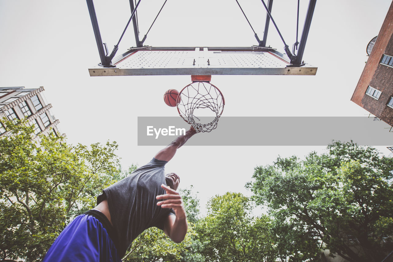 Low angle view of young man playing basketball