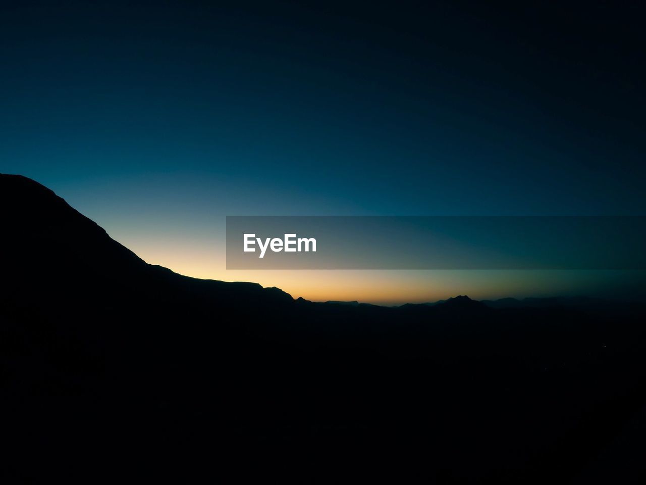 Scenic view of silhouette mountain against sky at sunset