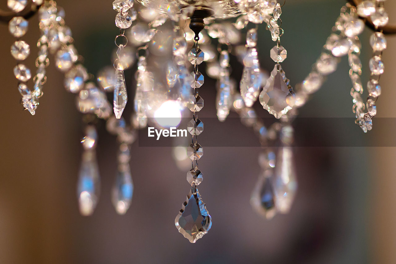Backlit close-up of crystals hanging from a beautiful decorative chandelier 