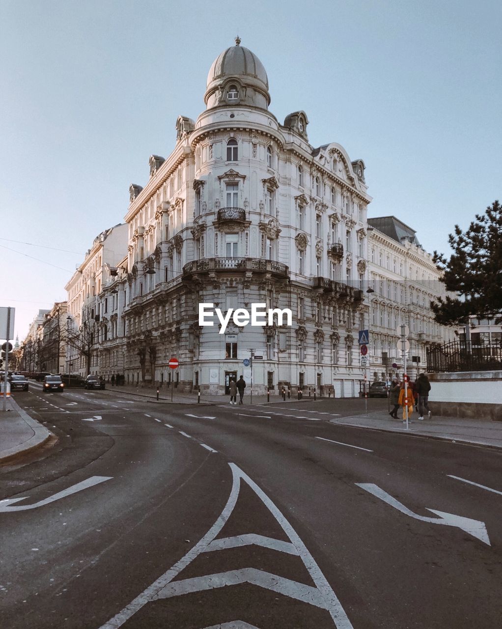 Road by buildings against clear sky