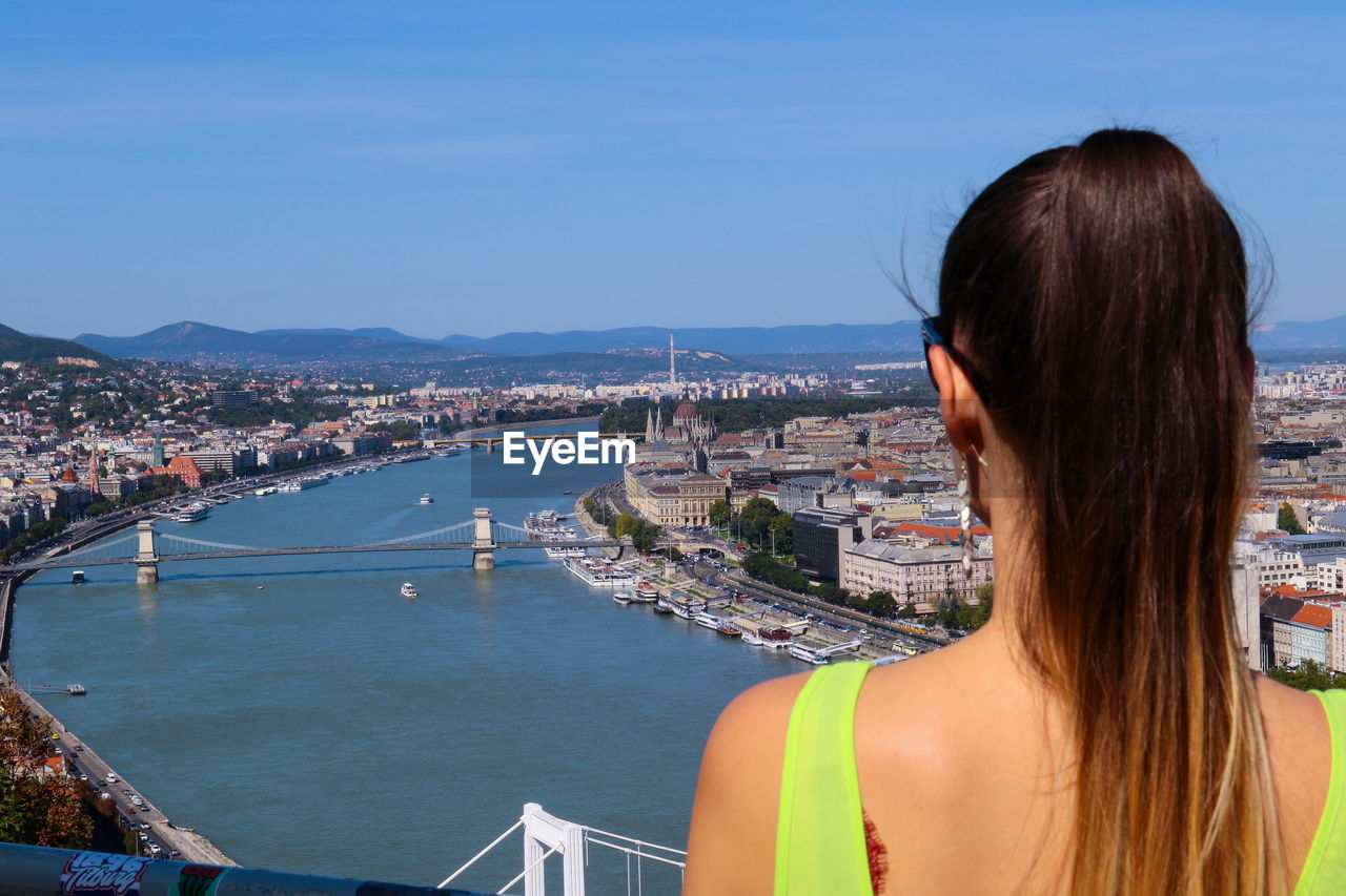 REAR VIEW OF WOMAN LOOKING AT CITY