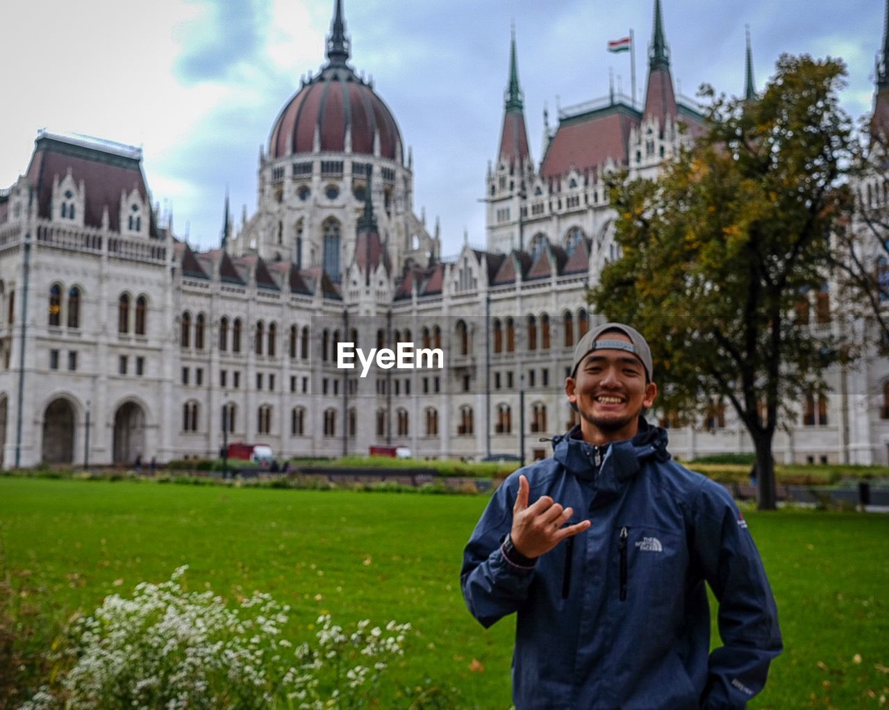 Portrait of smiling man standing against hungarian parliament building