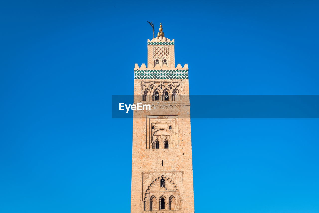 Low angle view of clock tower against blue sky