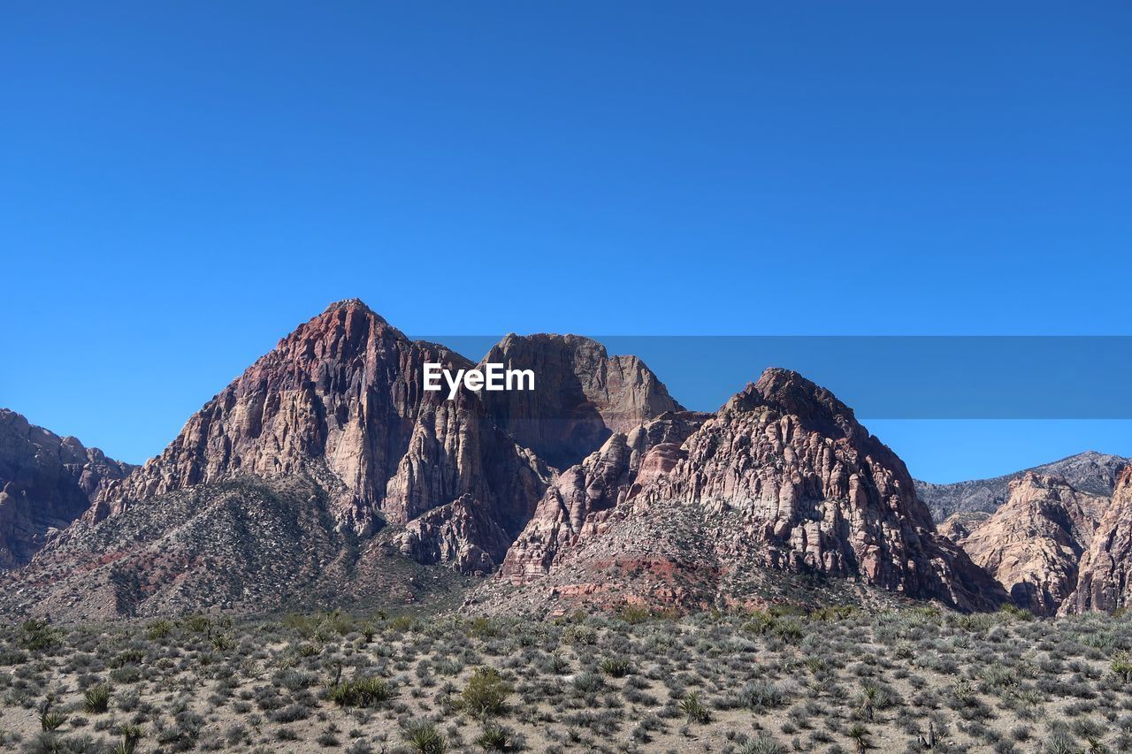 Scenic view of mountains against clear blue sky