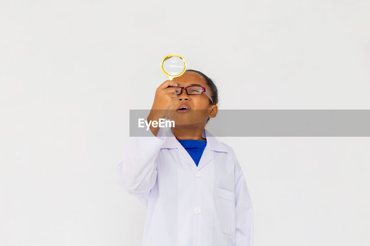 BOY LOOKING UP AGAINST WHITE BACKGROUND