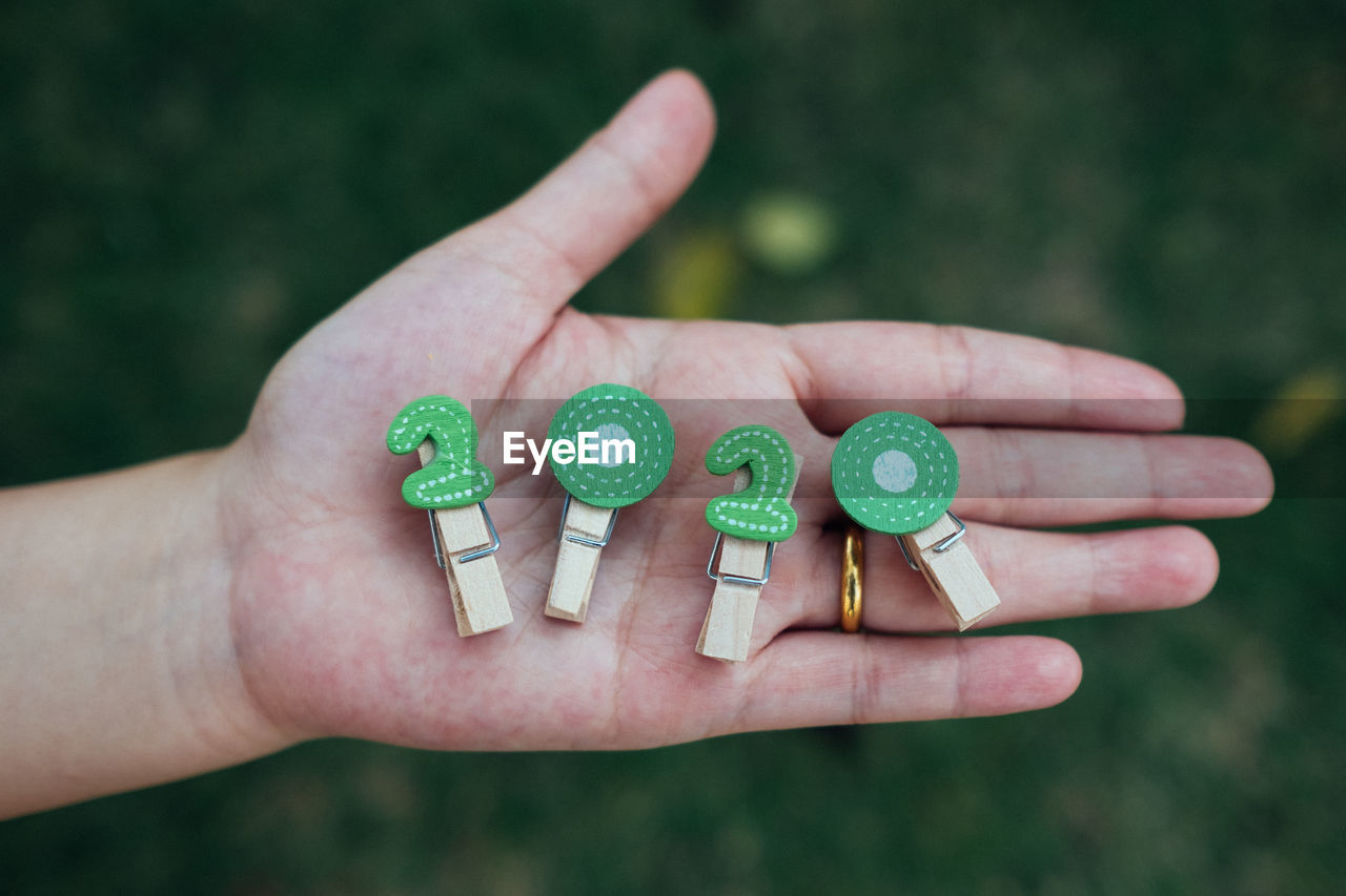 Cropped hand holding clothespins