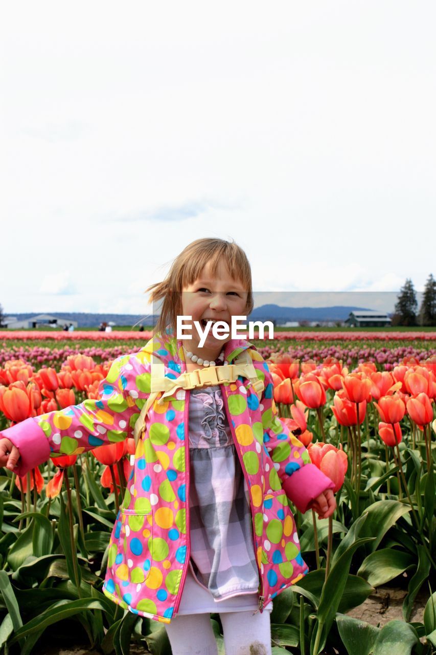 Portrait of cute happy little girl on tulip field