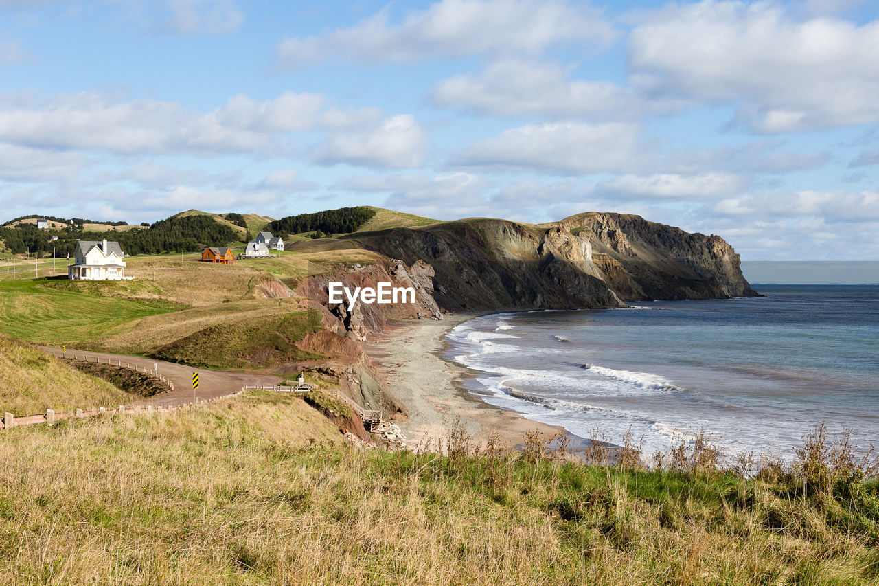 Fall landscape with beach and pretty traditional houses perched on cliff 