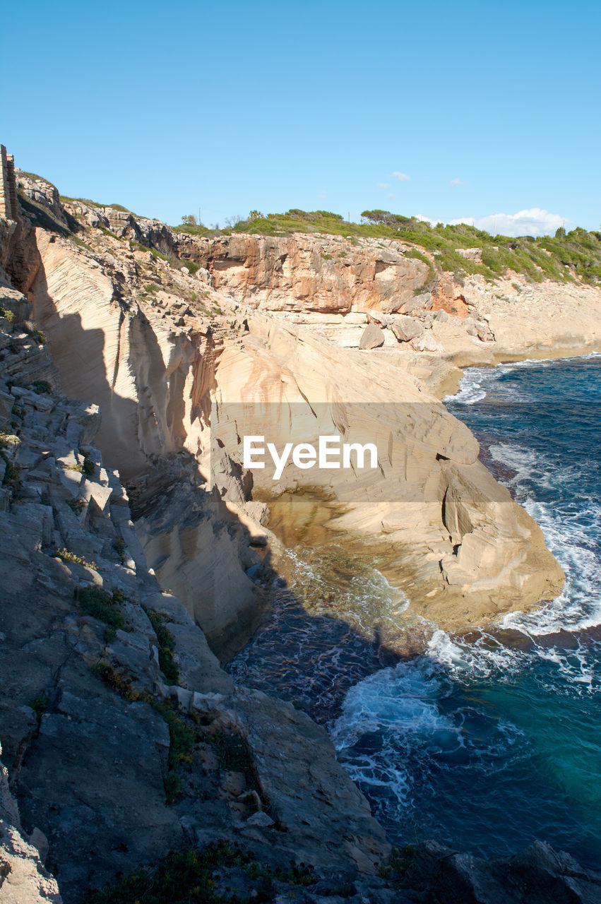 Vertical view, old abandoned quarry, of marés stone blocks, on the cliff of the mediterranean sea,