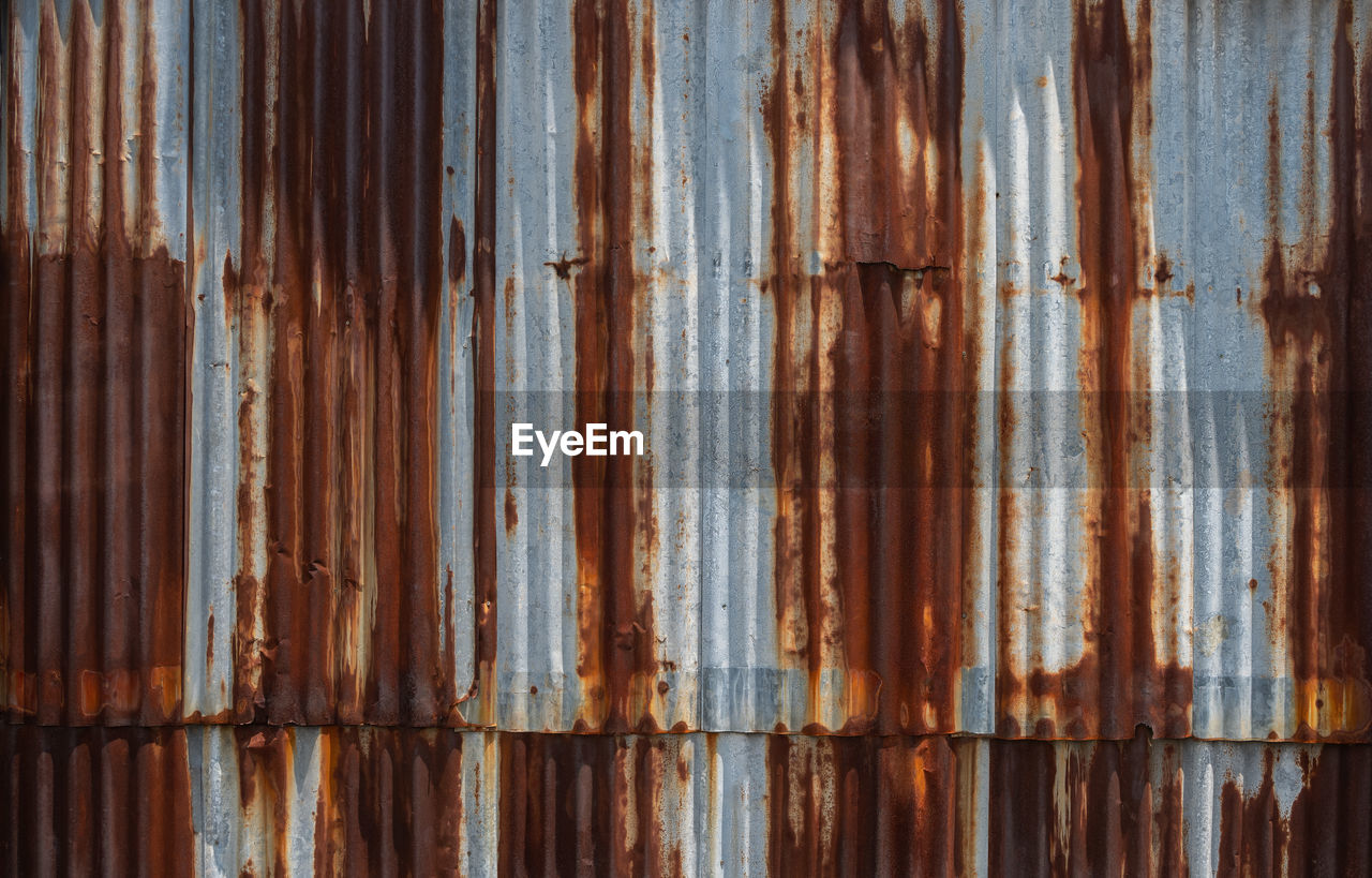 FULL FRAME SHOT OF OLD RUSTY METAL IN WOOD