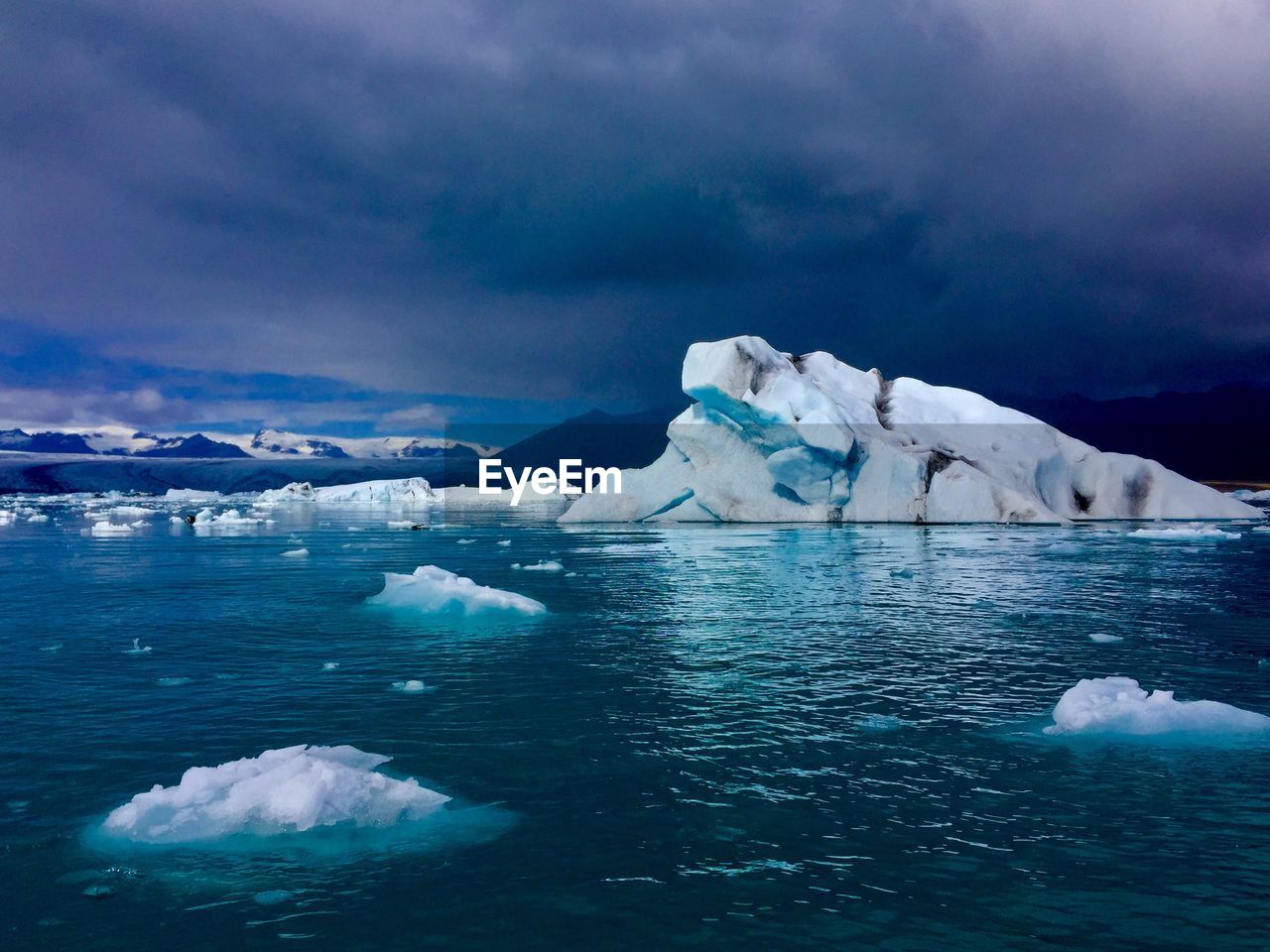 Scenic view of iceberg against sky during winter