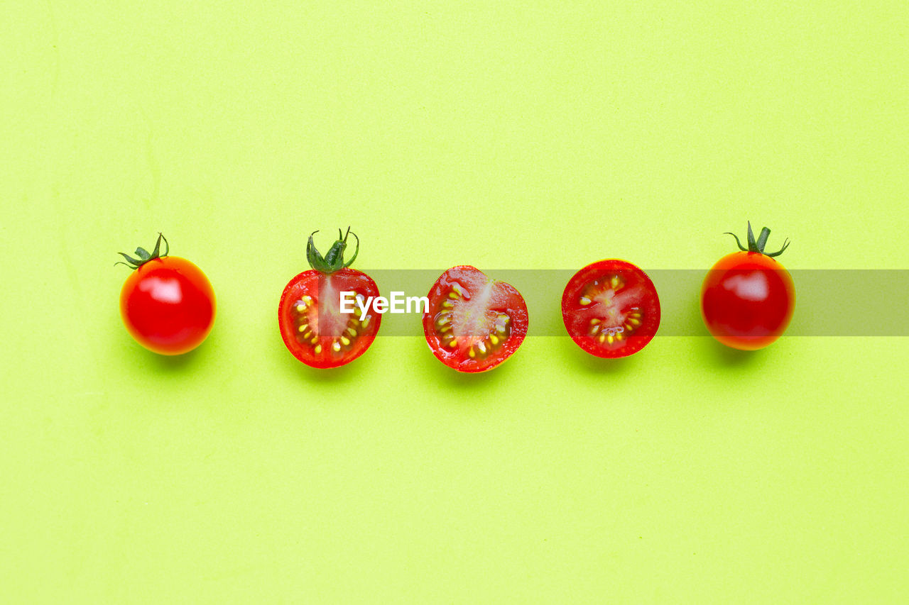 CLOSE-UP OF RED CHERRIES AGAINST WHITE BACKGROUND