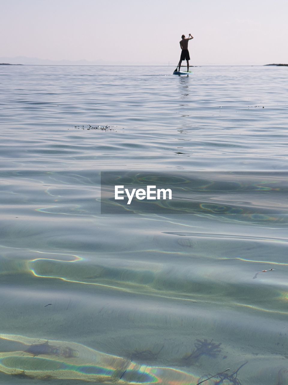 FULL LENGTH OF MAN IN SEA AGAINST SKY