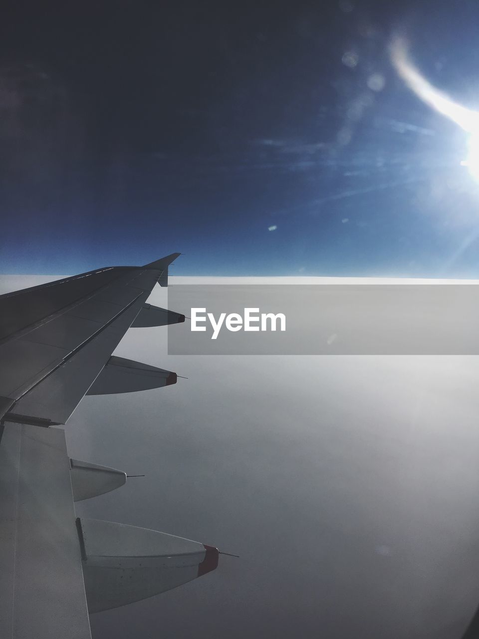 CLOSE-UP OF AIRPLANE FLYING OVER CLOUDS