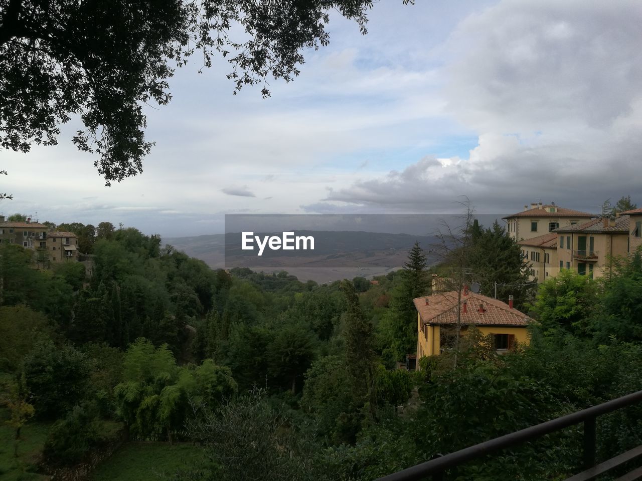 HOUSES AGAINST TREES AND MOUNTAINS AGAINST SKY