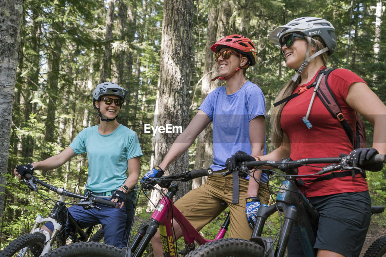 Three female friends mountain bike on a trail at mt. hood, oregon.