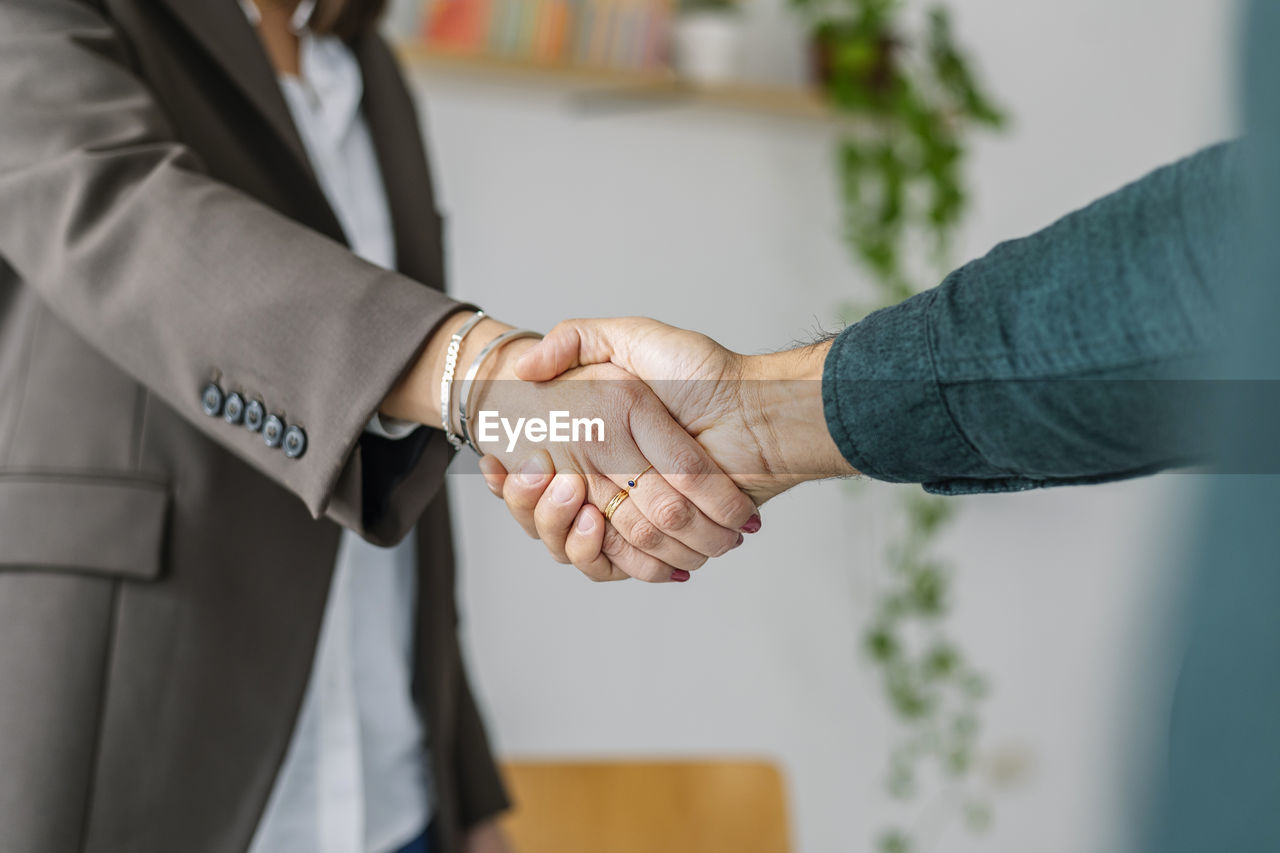 Recruiter shaking hand with candidate in office